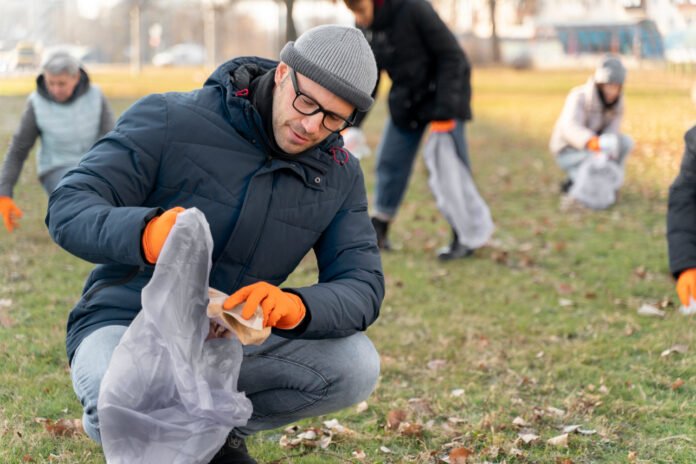 How should food workers keep garbage cans clean and free of buildup